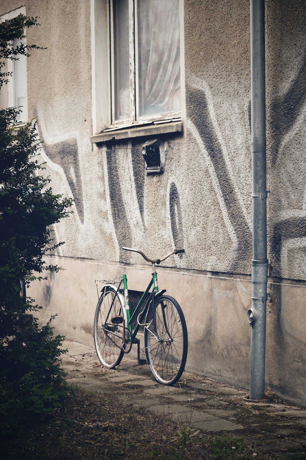a bike parked next to a building with graffiti on it