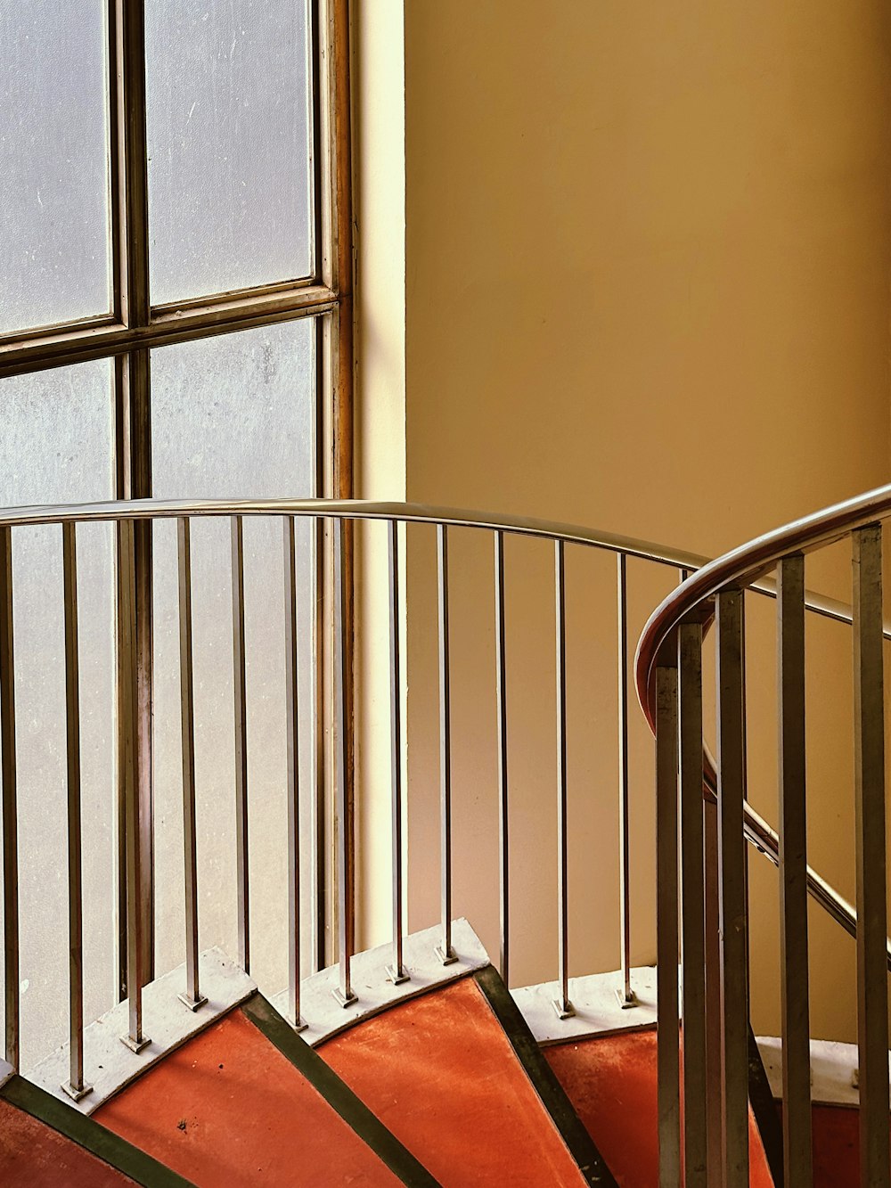 a spiral staircase next to a window in a building