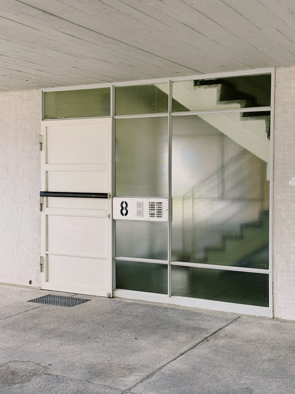 uma porta branca com um sinal em frente a um edifício