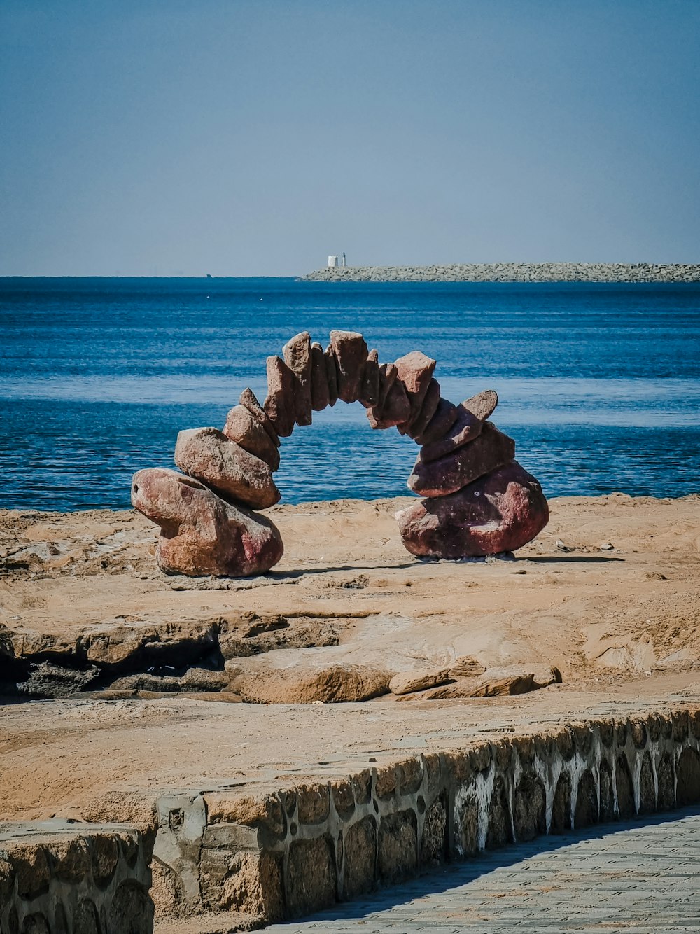 Eine große Felsformation, die auf einem Sandstrand sitzt