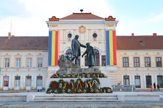 a statue of two men shaking hands in front of a building