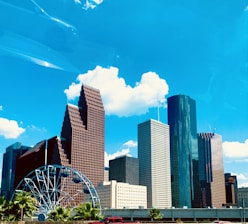 a city skyline with a ferris wheel in the foreground