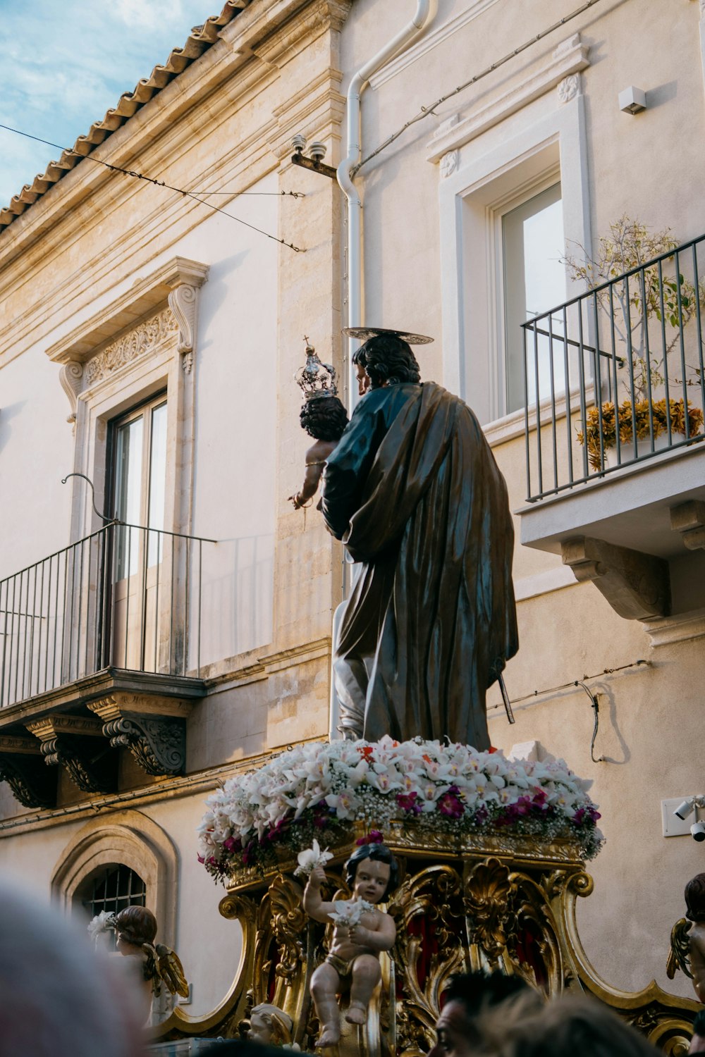 a statue of a man with a hat and a cane in front of a building