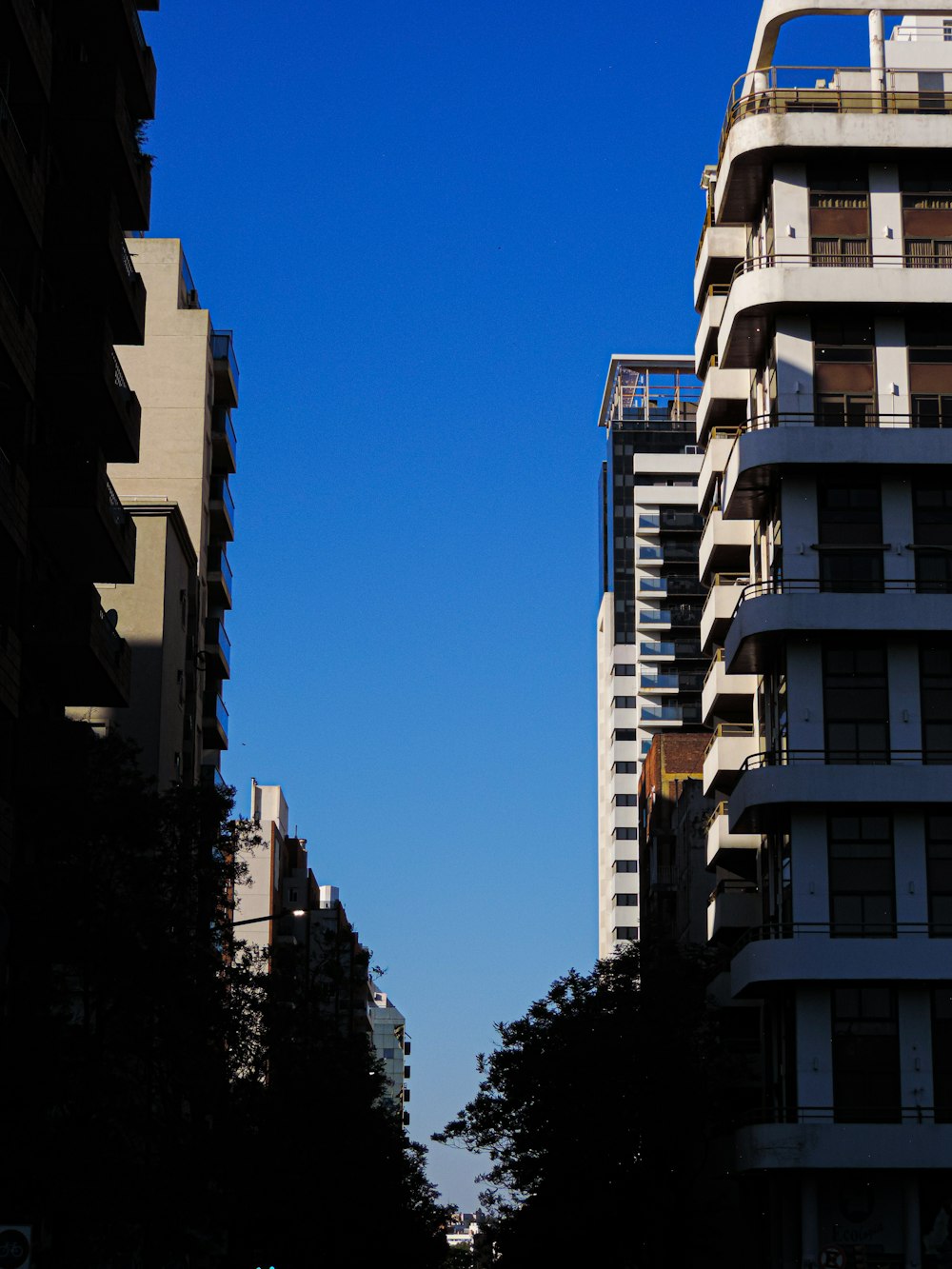 a city street with tall buildings and a blue sky