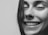A close-up of a smiling woman sharing her experience.