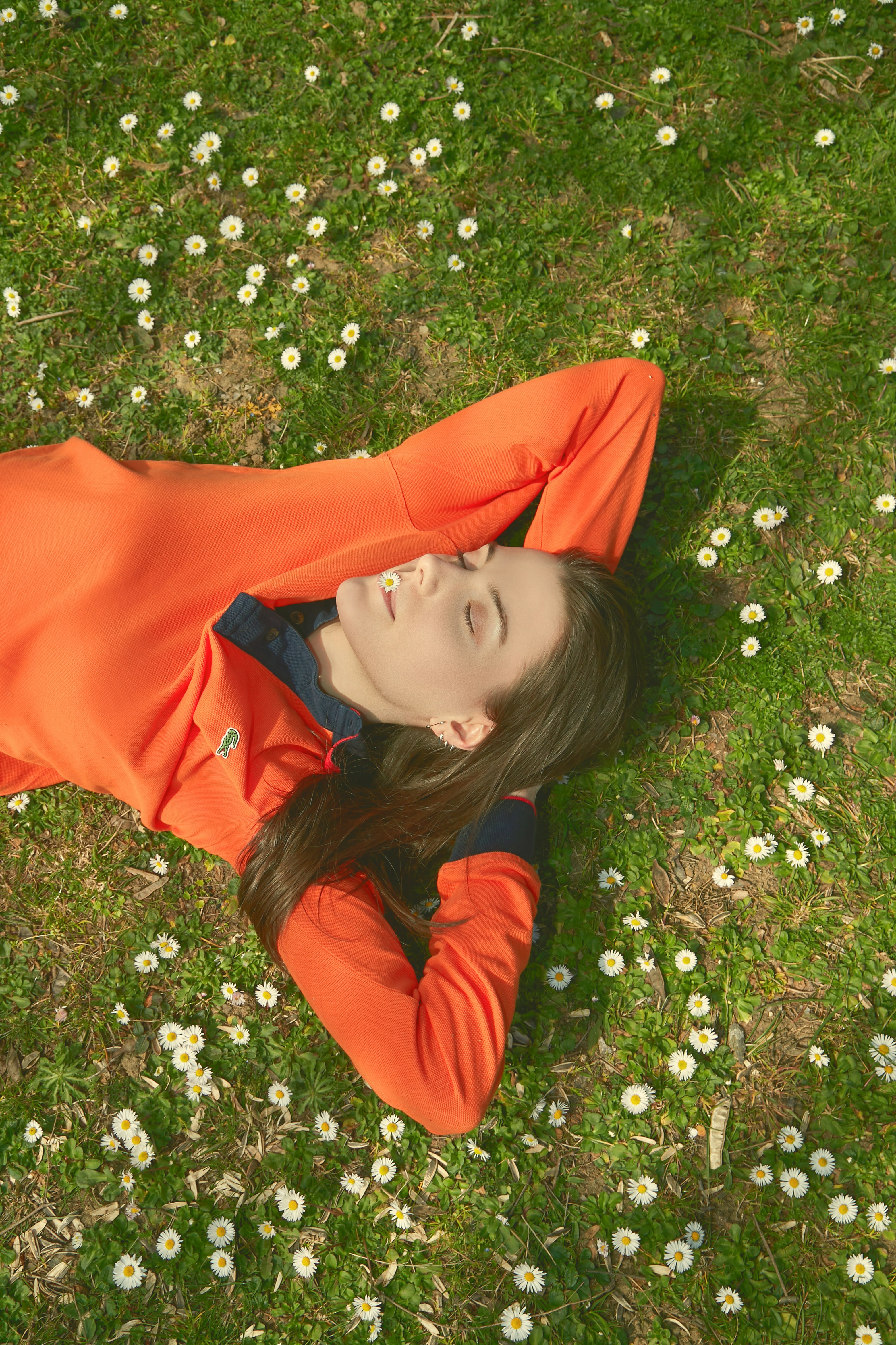 a woman laying on the ground in a field of flowers