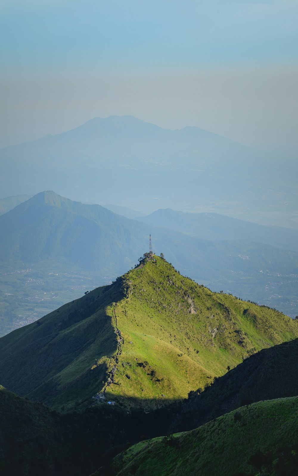 uma colina gramada com uma pequena torre no topo dela