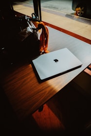 a laptop computer sitting on top of a wooden table