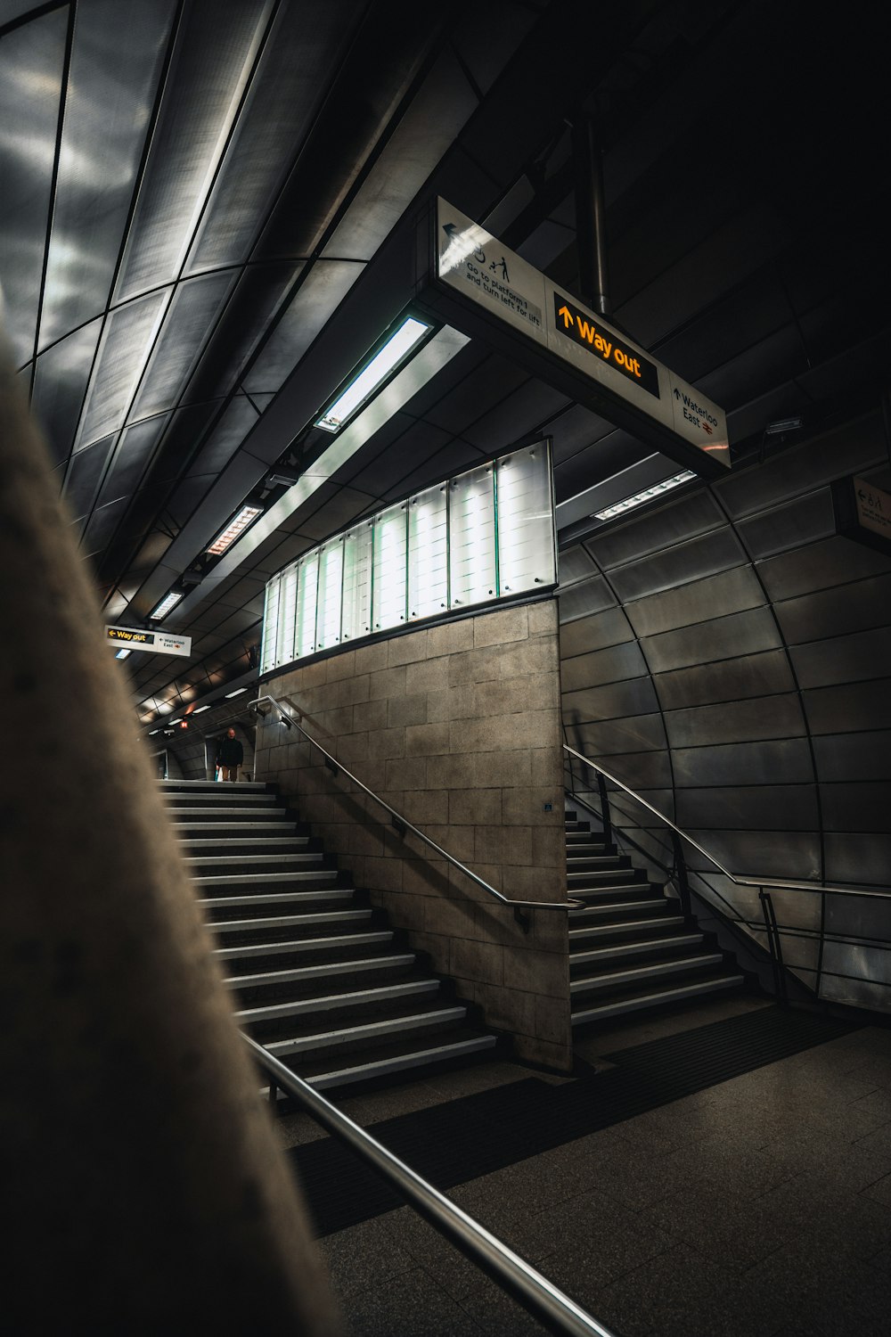 uma escada rolante e escadas em uma estação de metrô