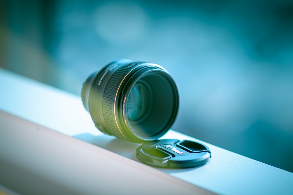 a camera lens sitting on top of a window sill