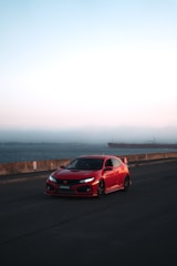 A sporty hatchback parked near a coastal road with the ocean in the background.