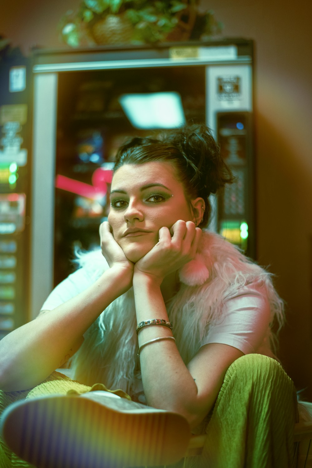 a woman sitting in front of a vending machine