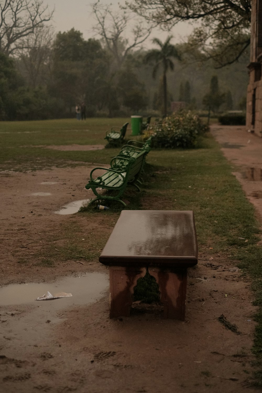 a couple of benches sitting on top of a dirt field