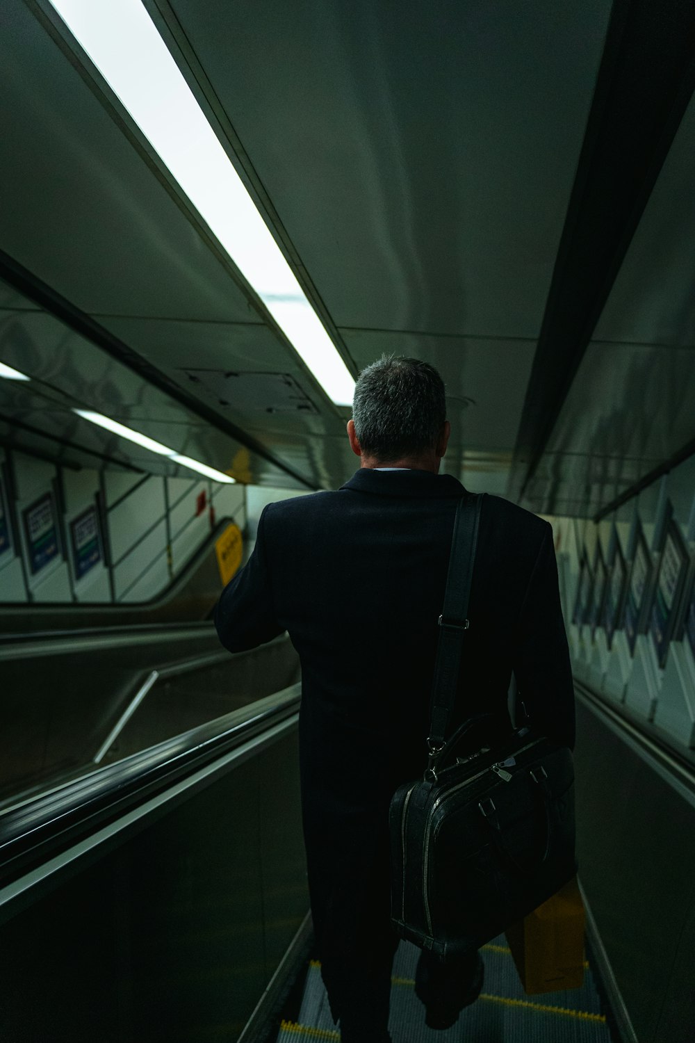 a man in a suit walking down an escalator