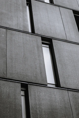 Close-up of fiber cement panels being installed on a modern apartment building exterior.