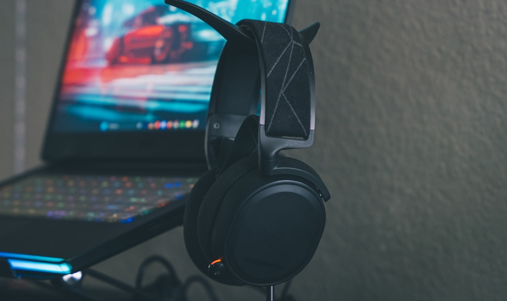 a close up of a pair of headphones next to a laptop