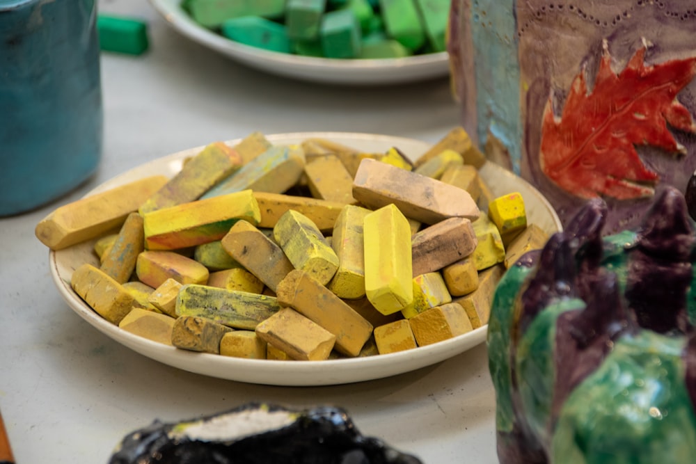 a plate of yellow and green candy on a table