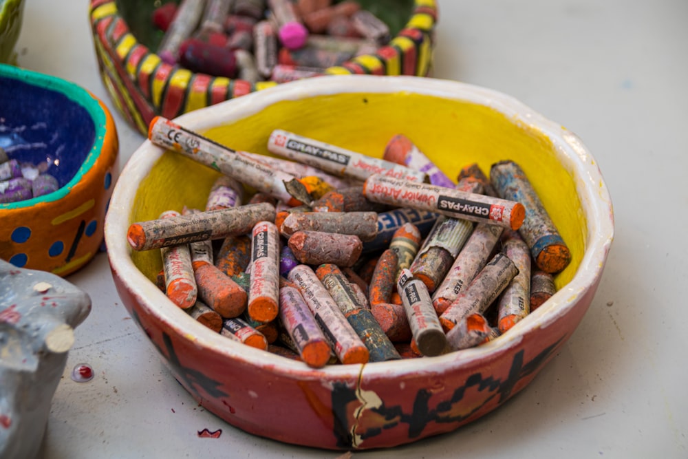 a bowl full of crayons sitting on a table
