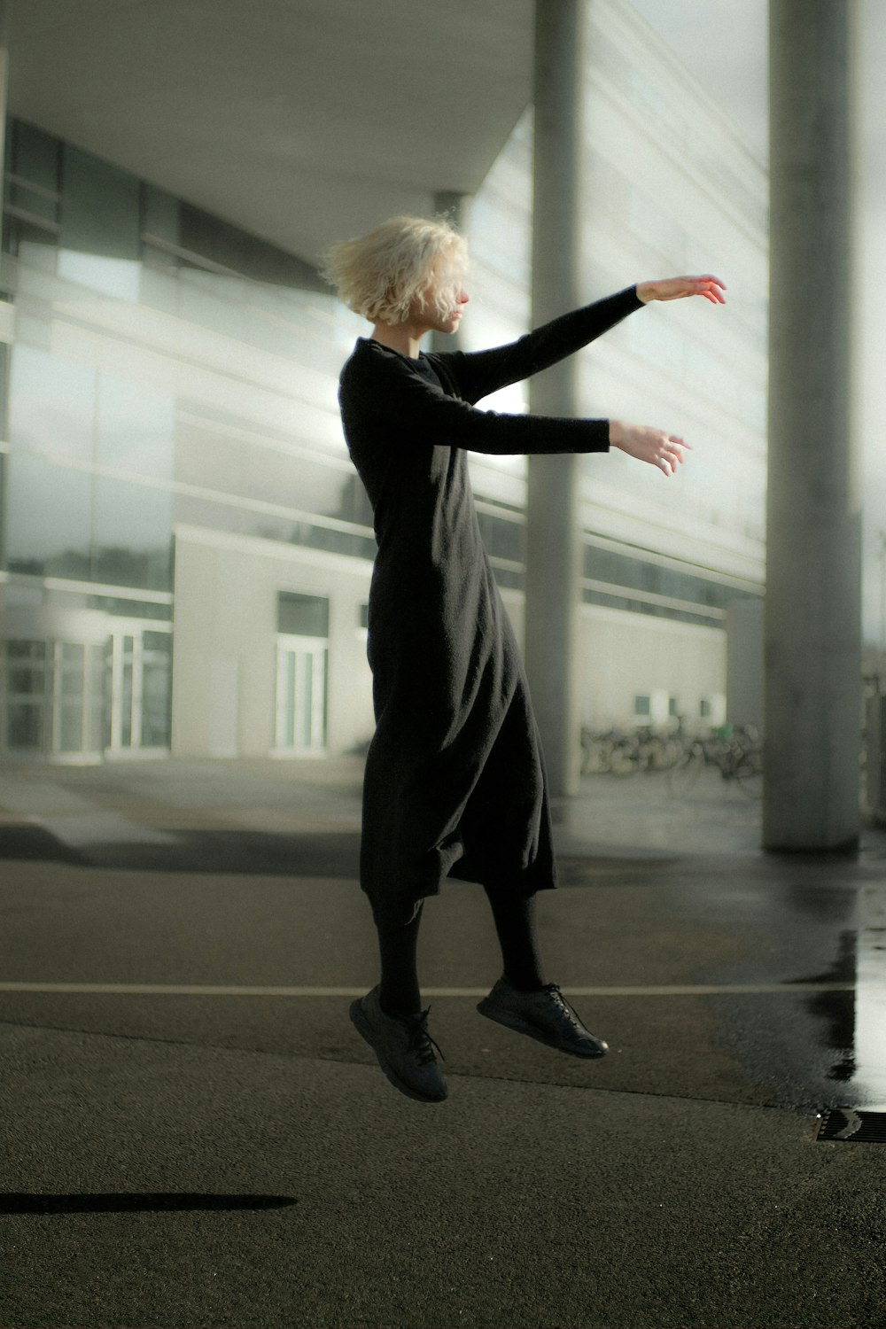 Une femme en robe noire saute en l’air