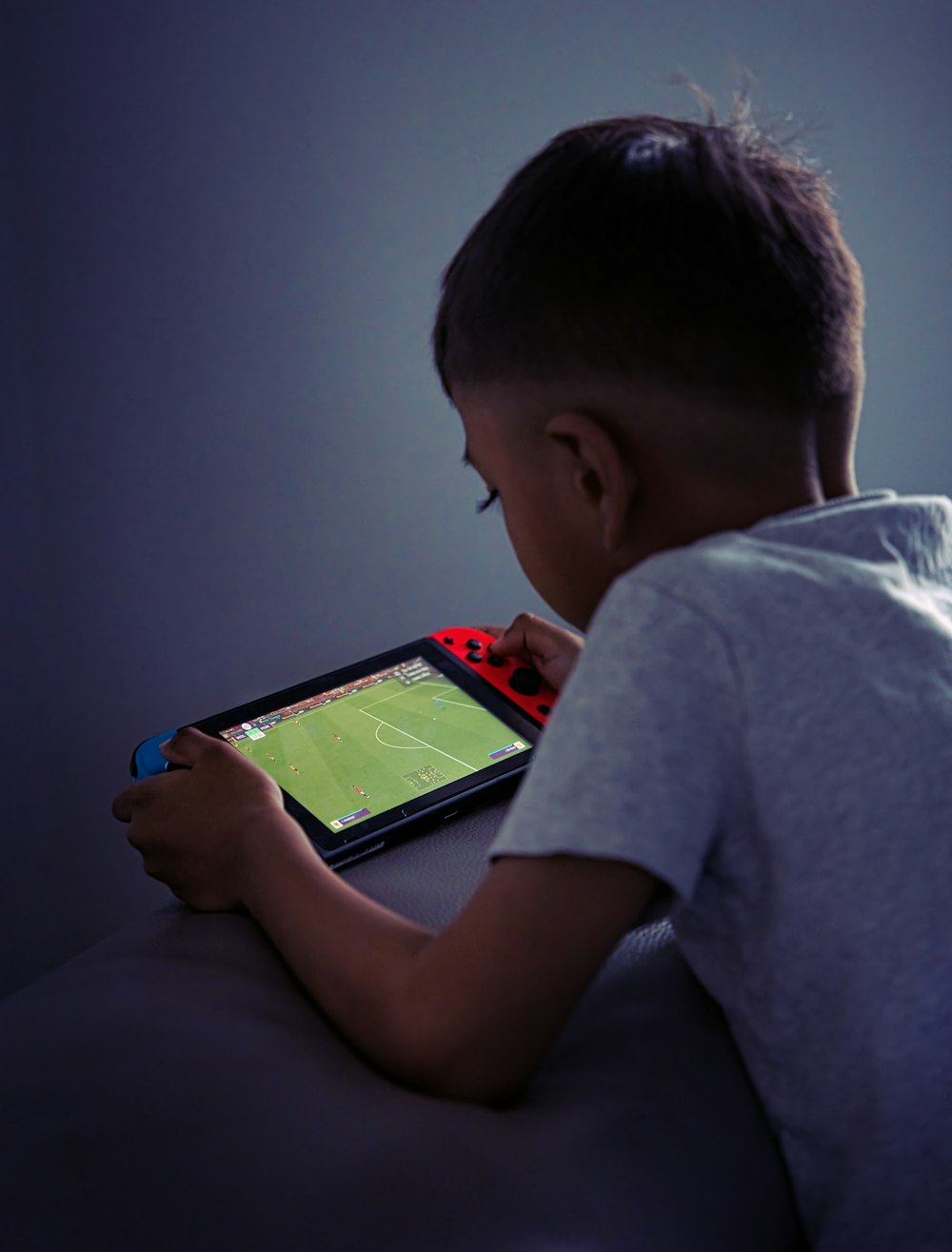 a young boy playing a video game on a tablet