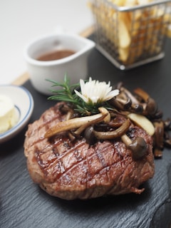 A rustic wooden platter with a medium-rare steak, roasted vegetables, and a side of herb butter.