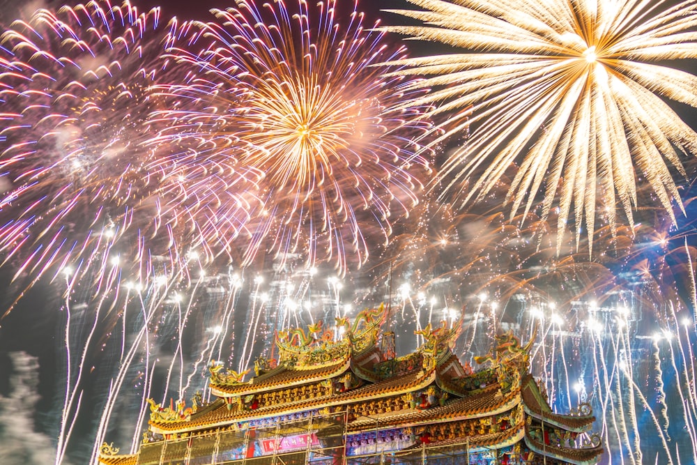 a large fireworks display in the sky above a building