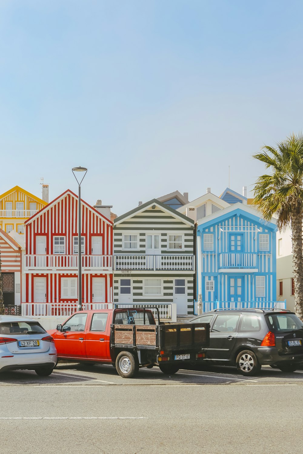 a truck is parked in front of a row of colorful houses