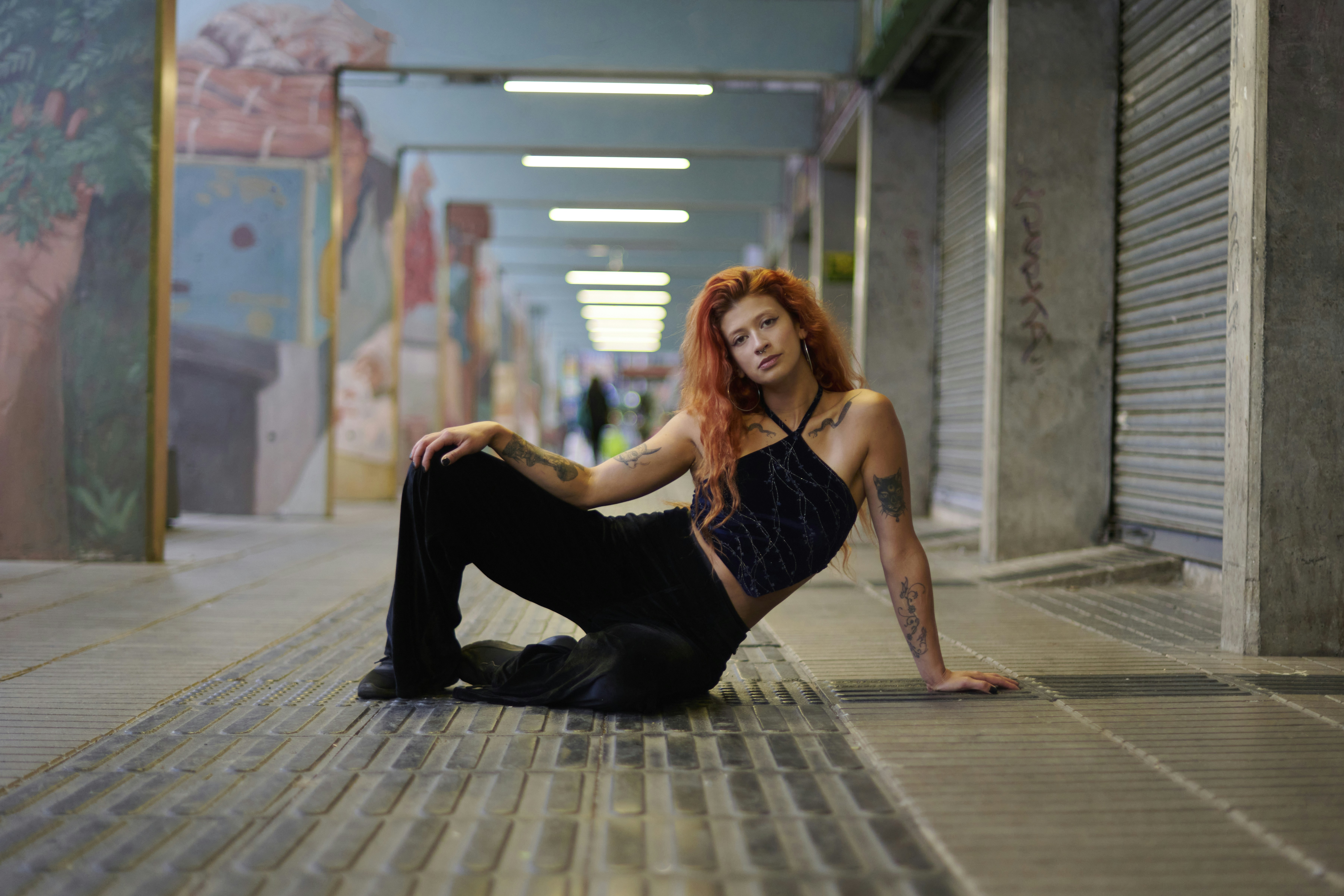 a woman with red hair sitting on the ground