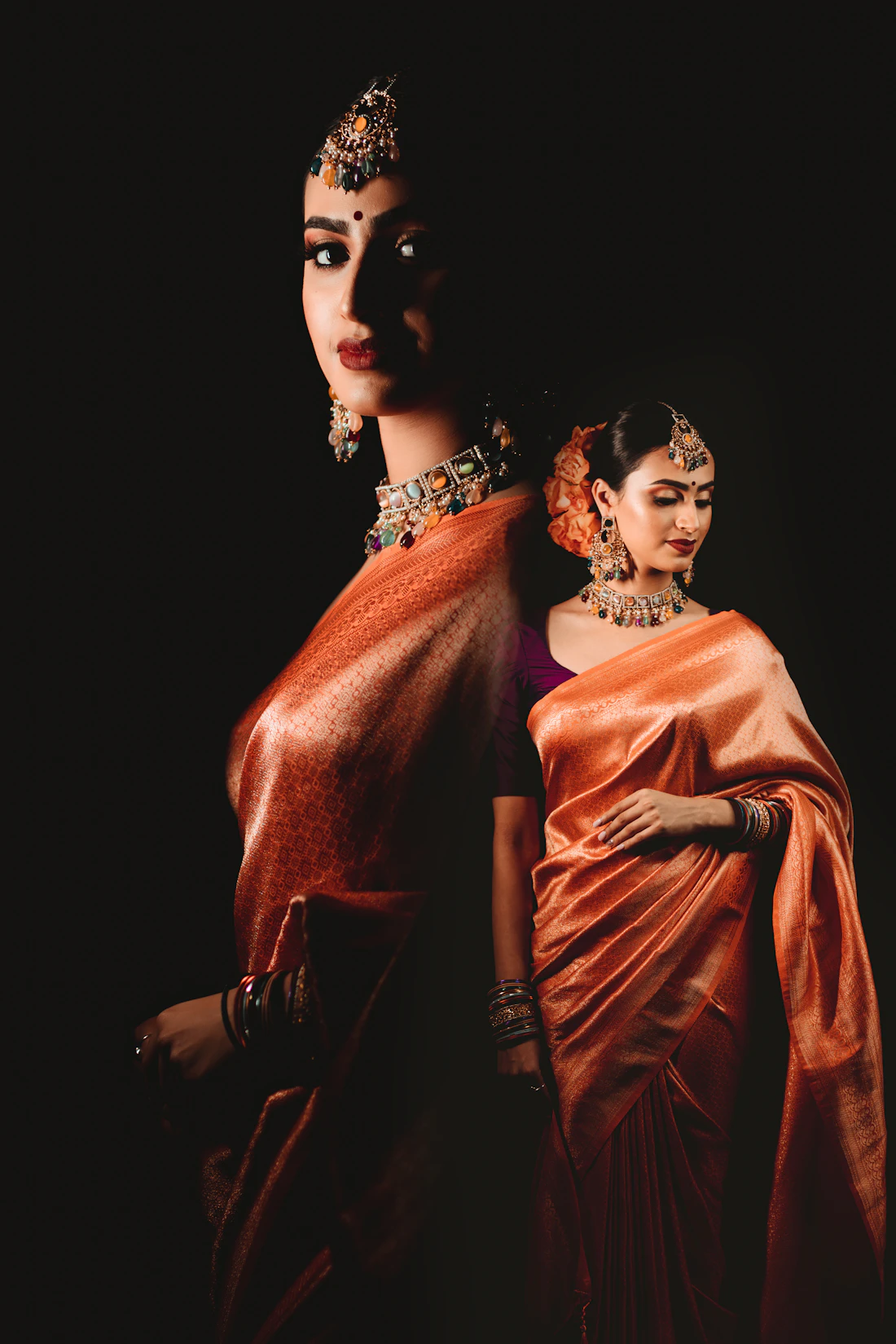 Two women in saris and jewellery