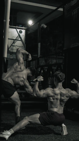 Close-up of a client’s back muscles before and after weight training at energofit, lit by bold yellow gym lights.