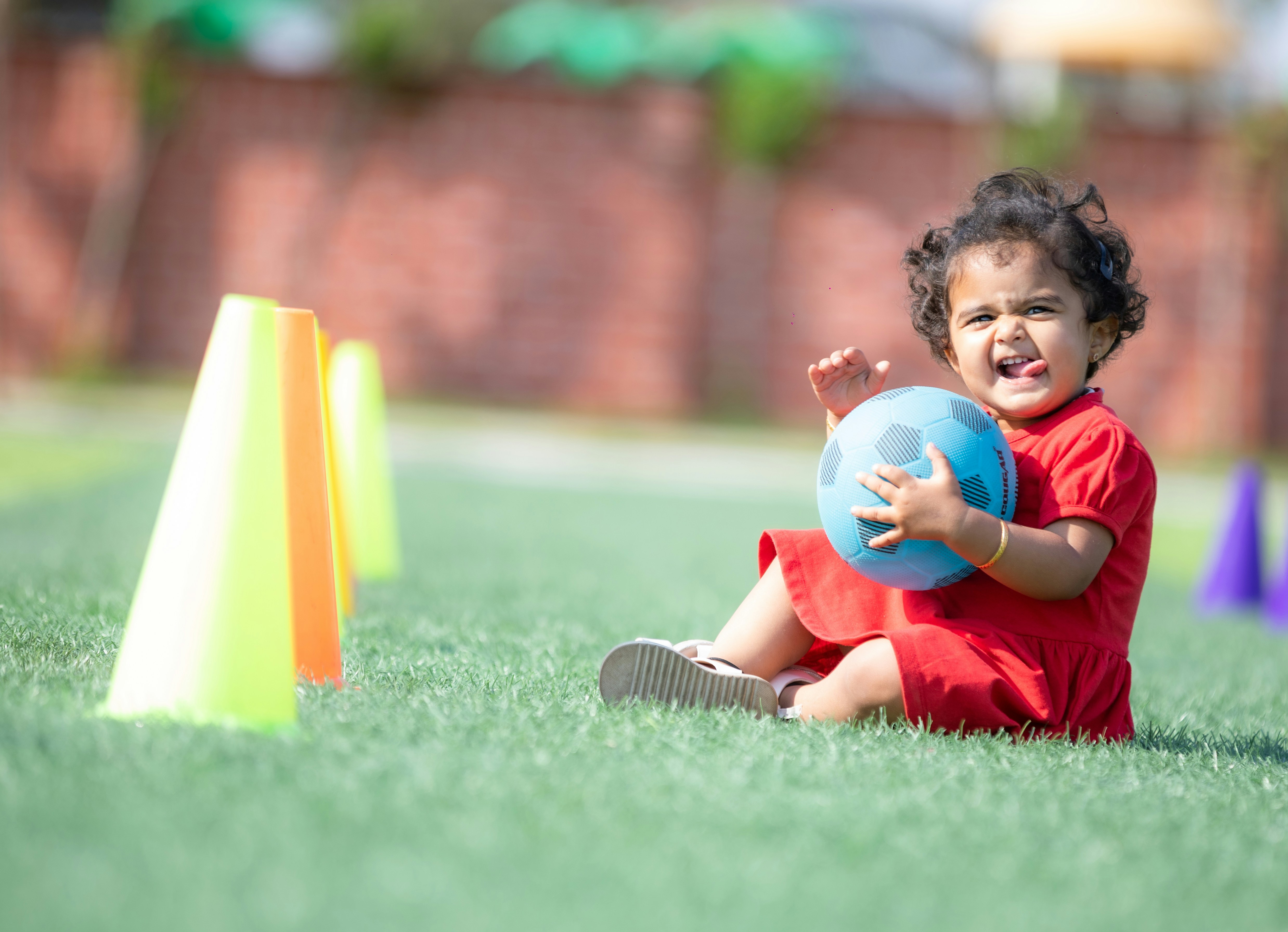 Baby boy in toddler football suit playing with a ball
