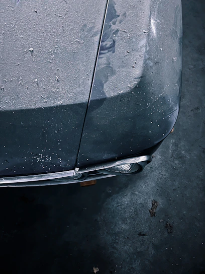 Close-up of a sleek car hood before detailing, showing dirt and minor scratches.