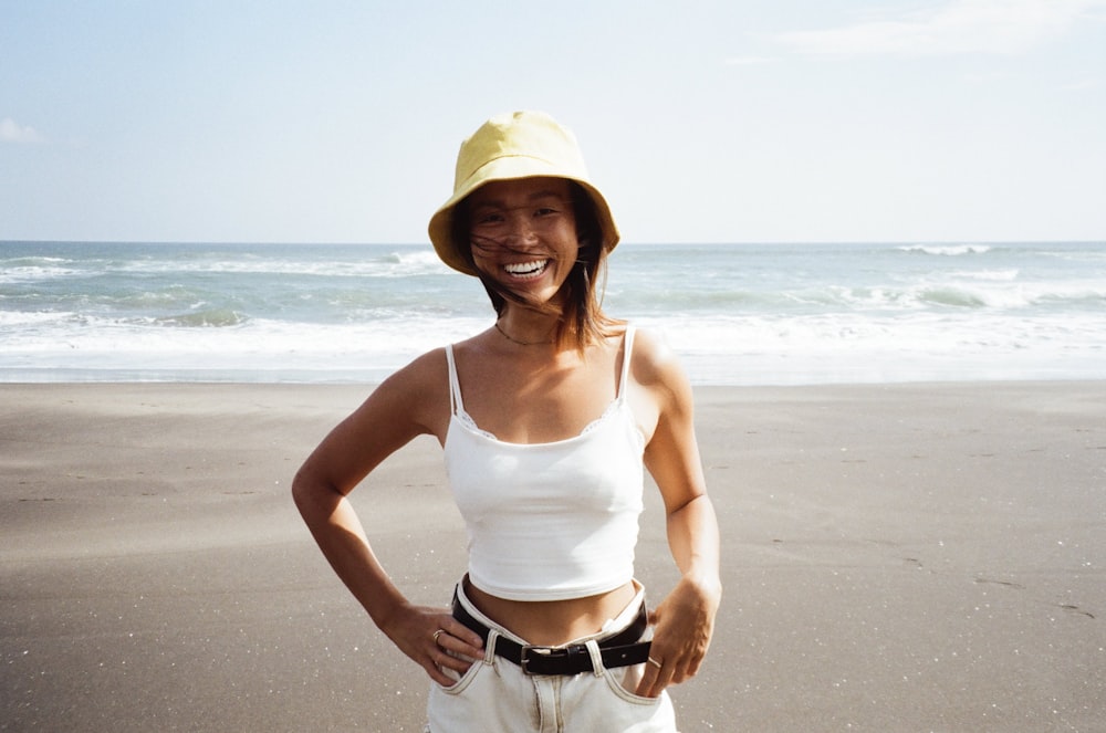 a woman standing on a beach with her hands on her hips