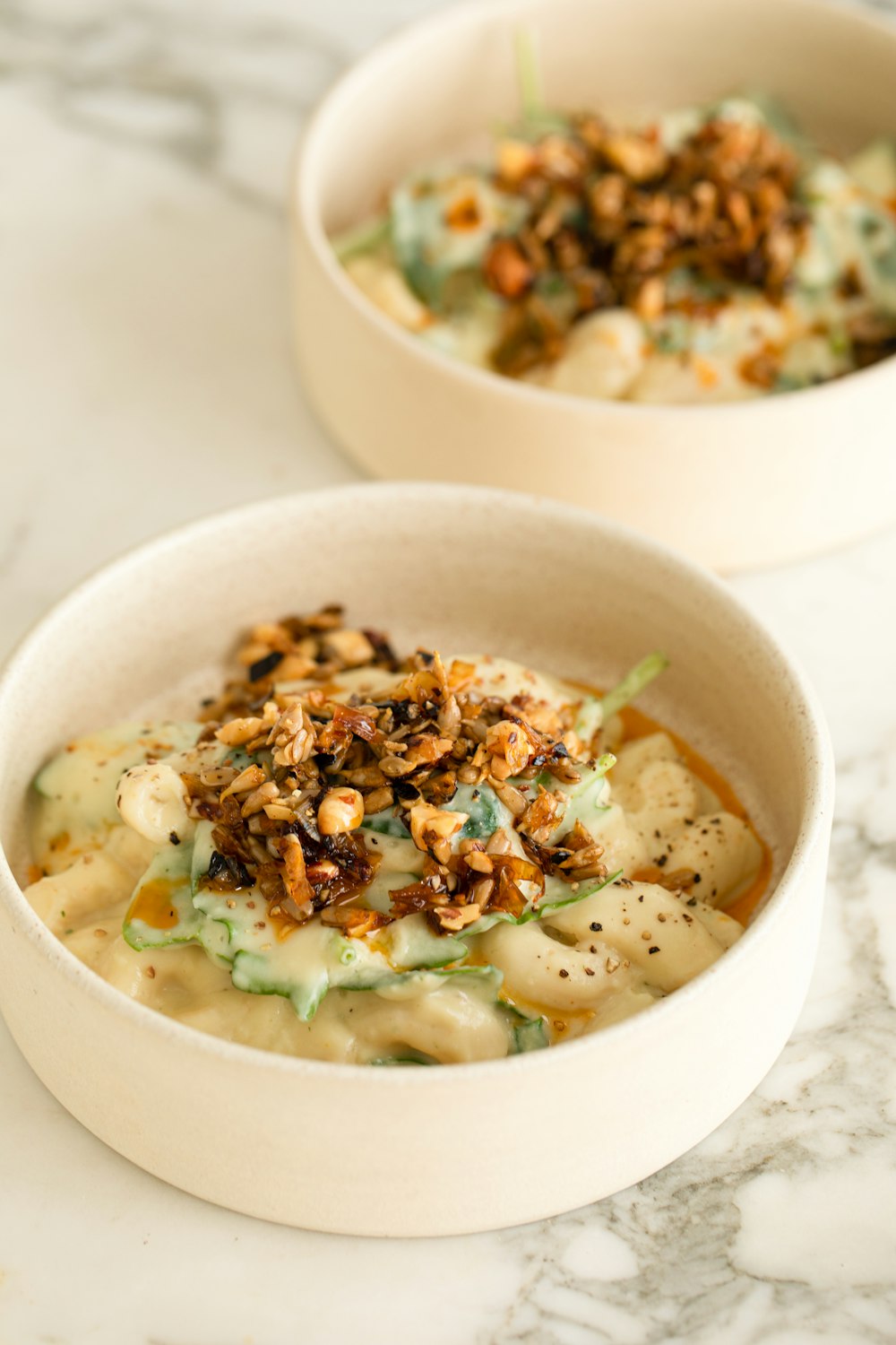 two bowls of food on a marble table