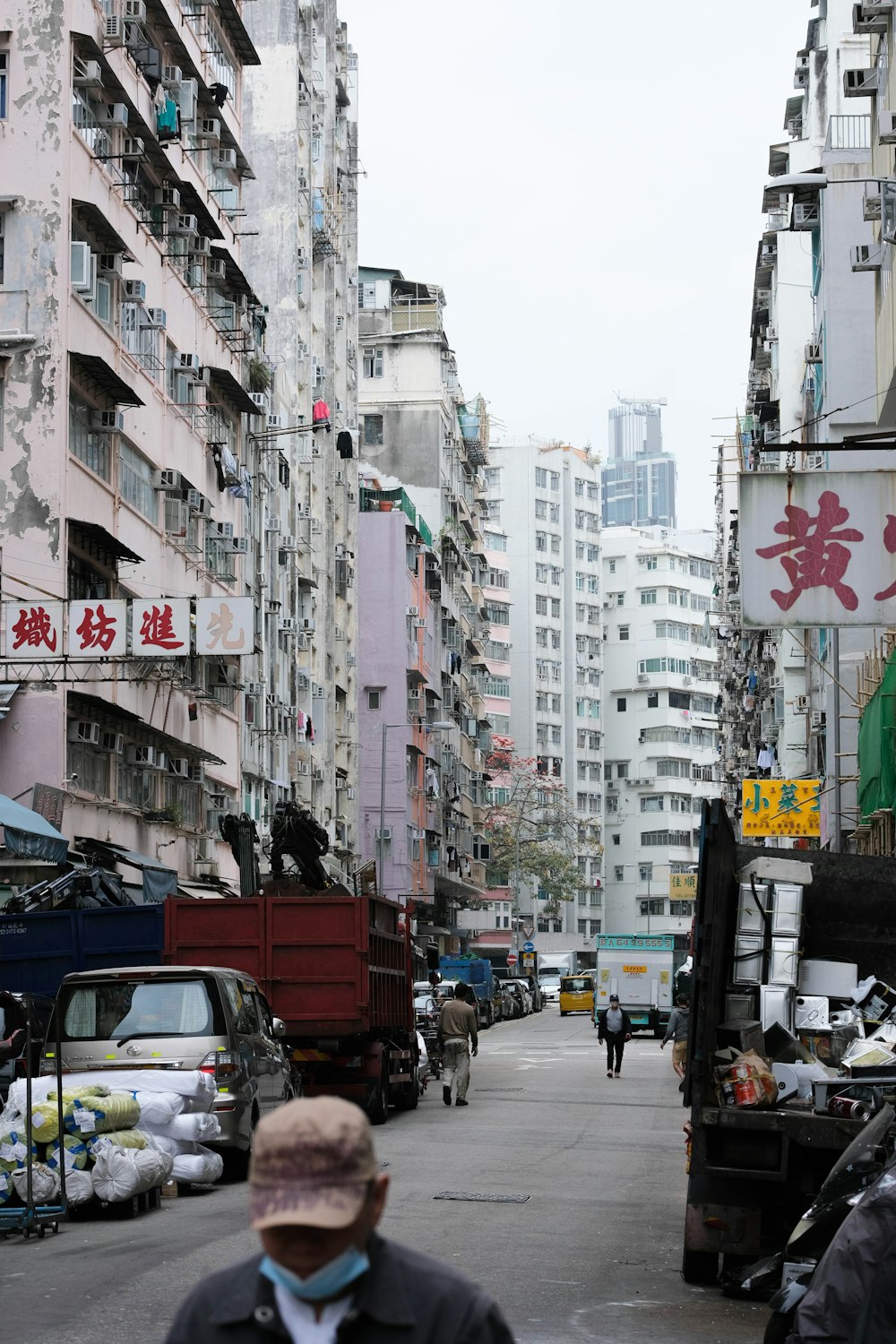 a man walking down a street next to tall buildings