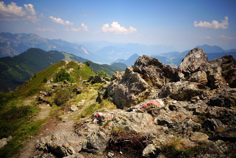 a view of a mountain with rocks and grass in the foreground