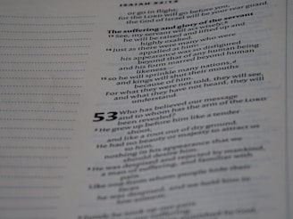A close-up of a page from a document or book with printed text. The content appears to be structured in verses or lines, suggesting it might be from religious or poetic literature. The text is clear and formatted with both regular and bold fonts, with some numbers indicating sections.