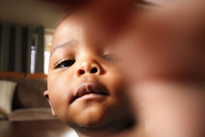 A candid shot of Shaira Arshi reaching out with tiny hands, curiosity sparkling in her eyes.