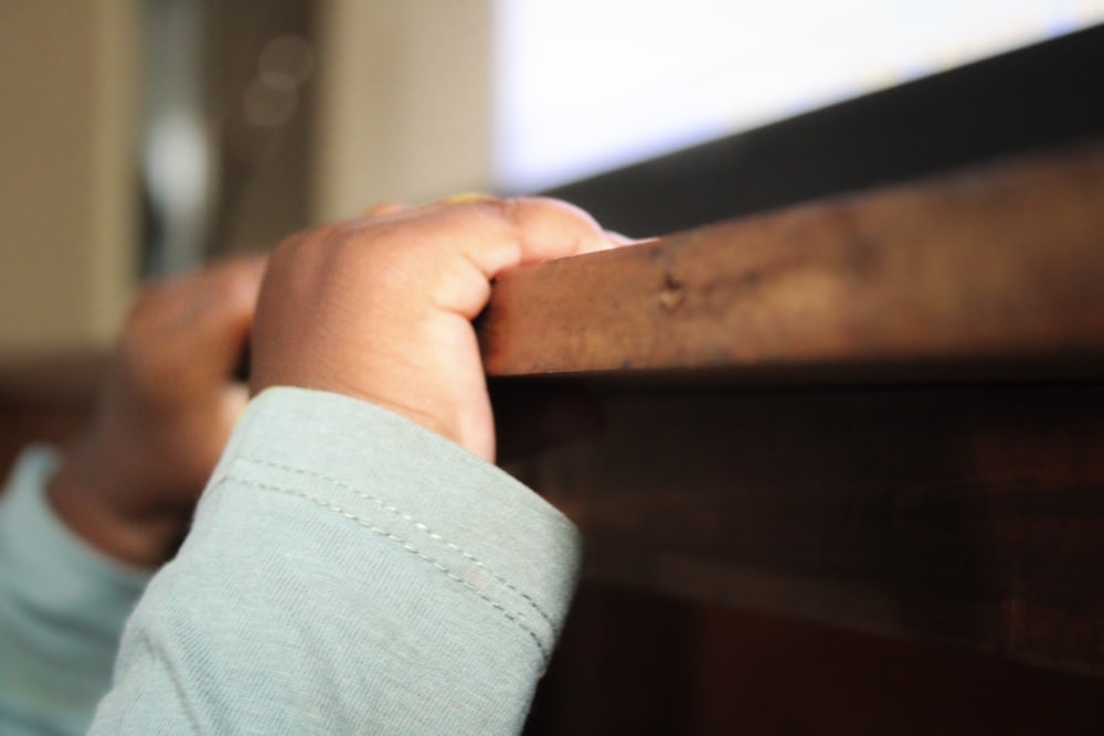 a close up of a child's hand on a rail