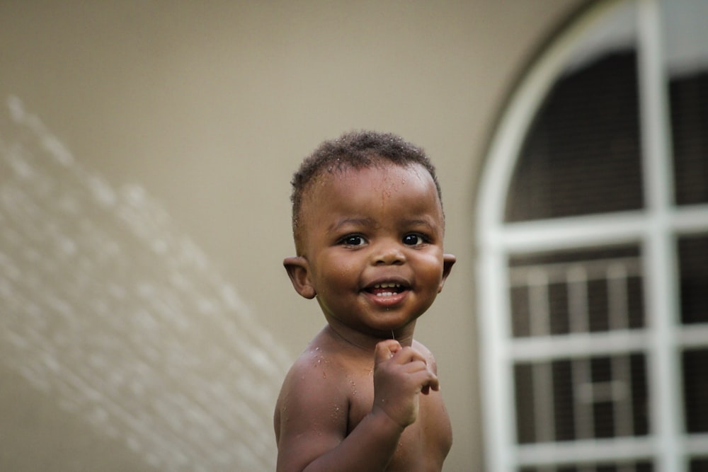 a young boy standing in front of a window