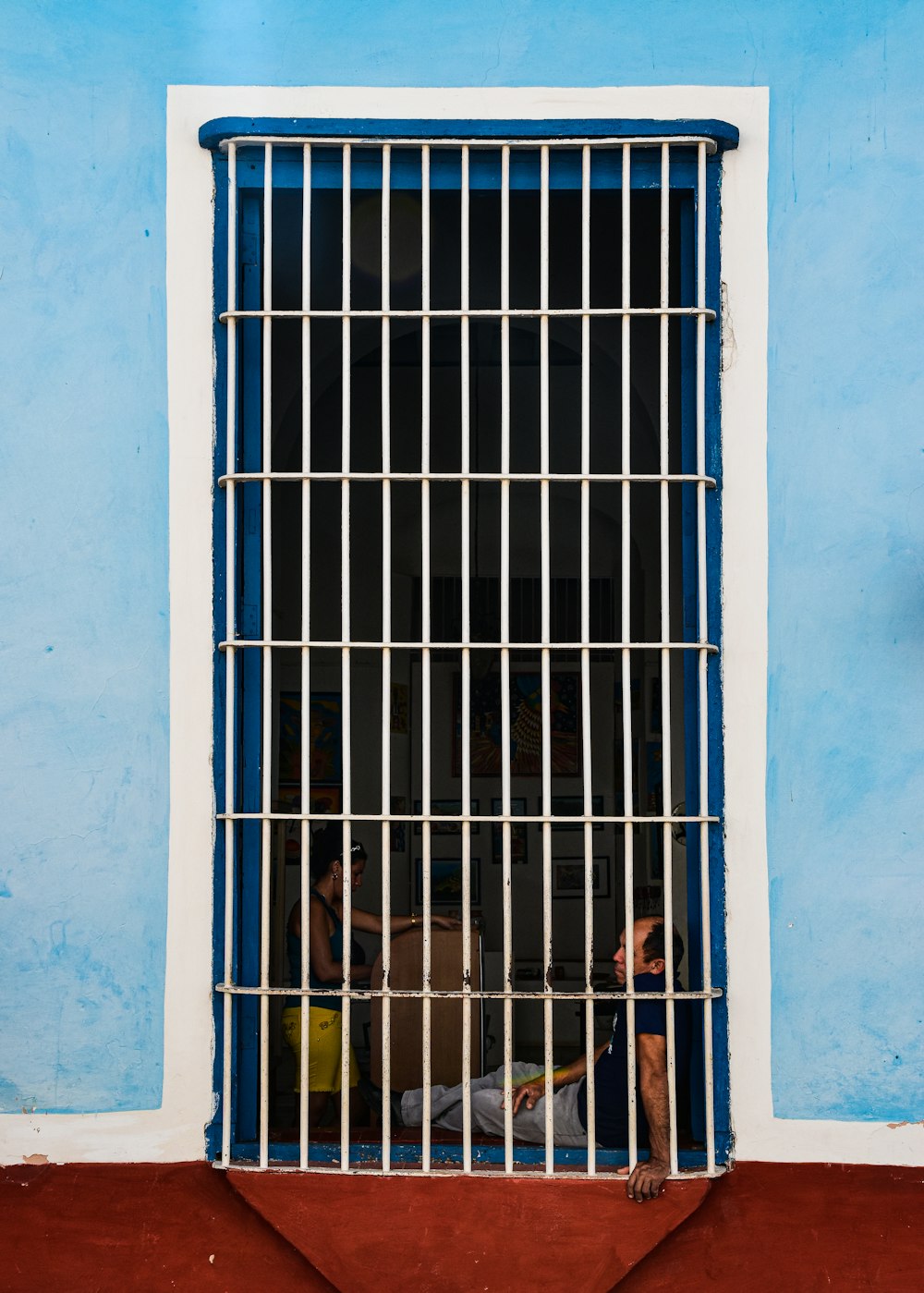 a man sitting in a jail cell behind bars