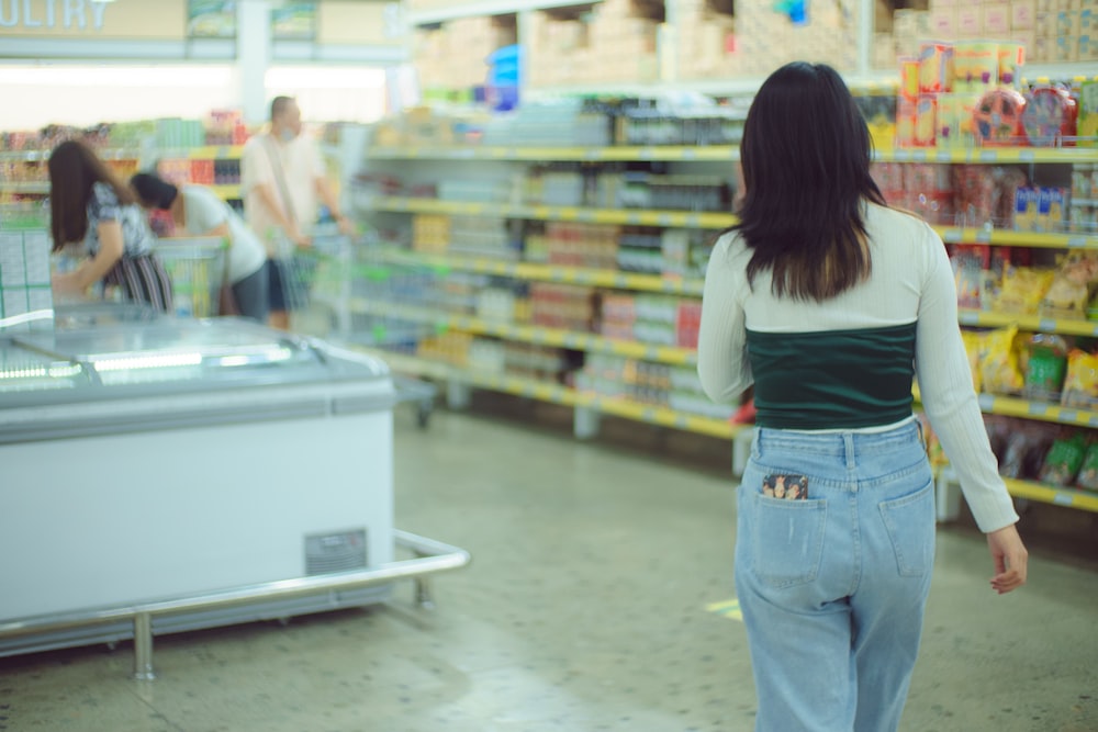 a woman is walking through a grocery store