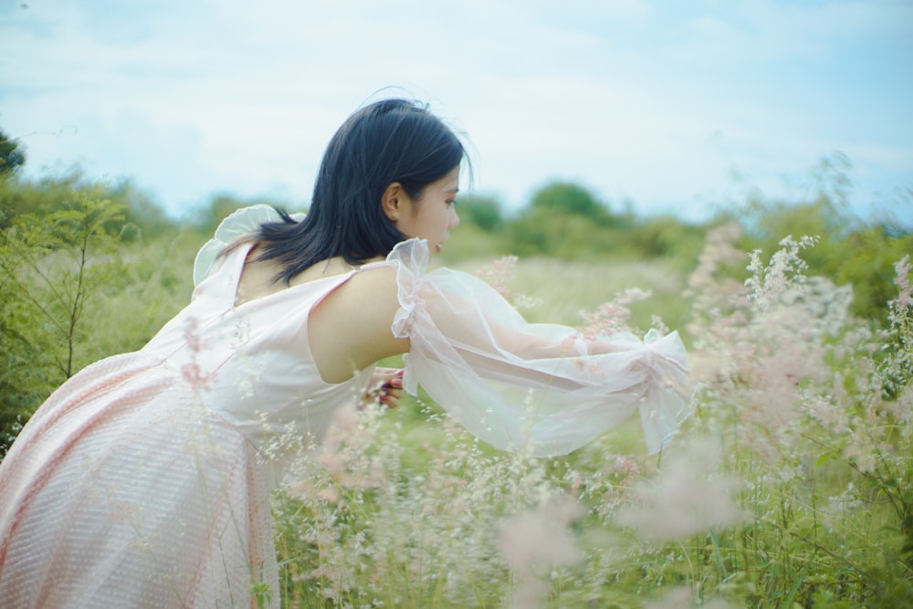 a woman standing in a field of tall grass