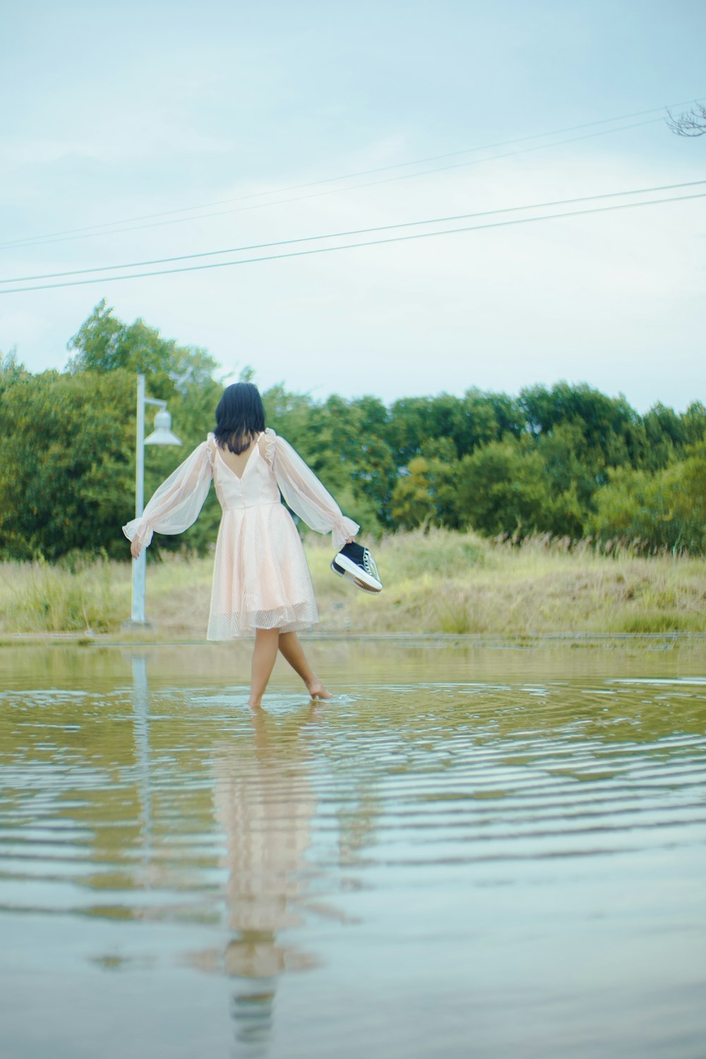 a woman in a pink dress is standing in the water