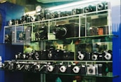 An elegant display of various high-end cameras arranged artfully on a glass shelf.