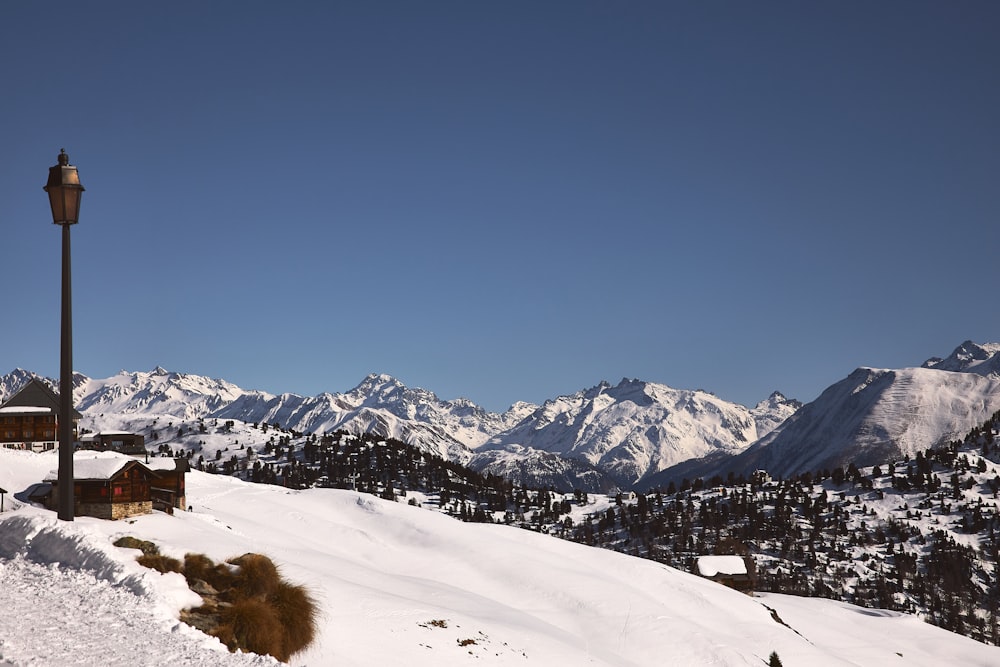 a lamp post on top of a snow covered mountain