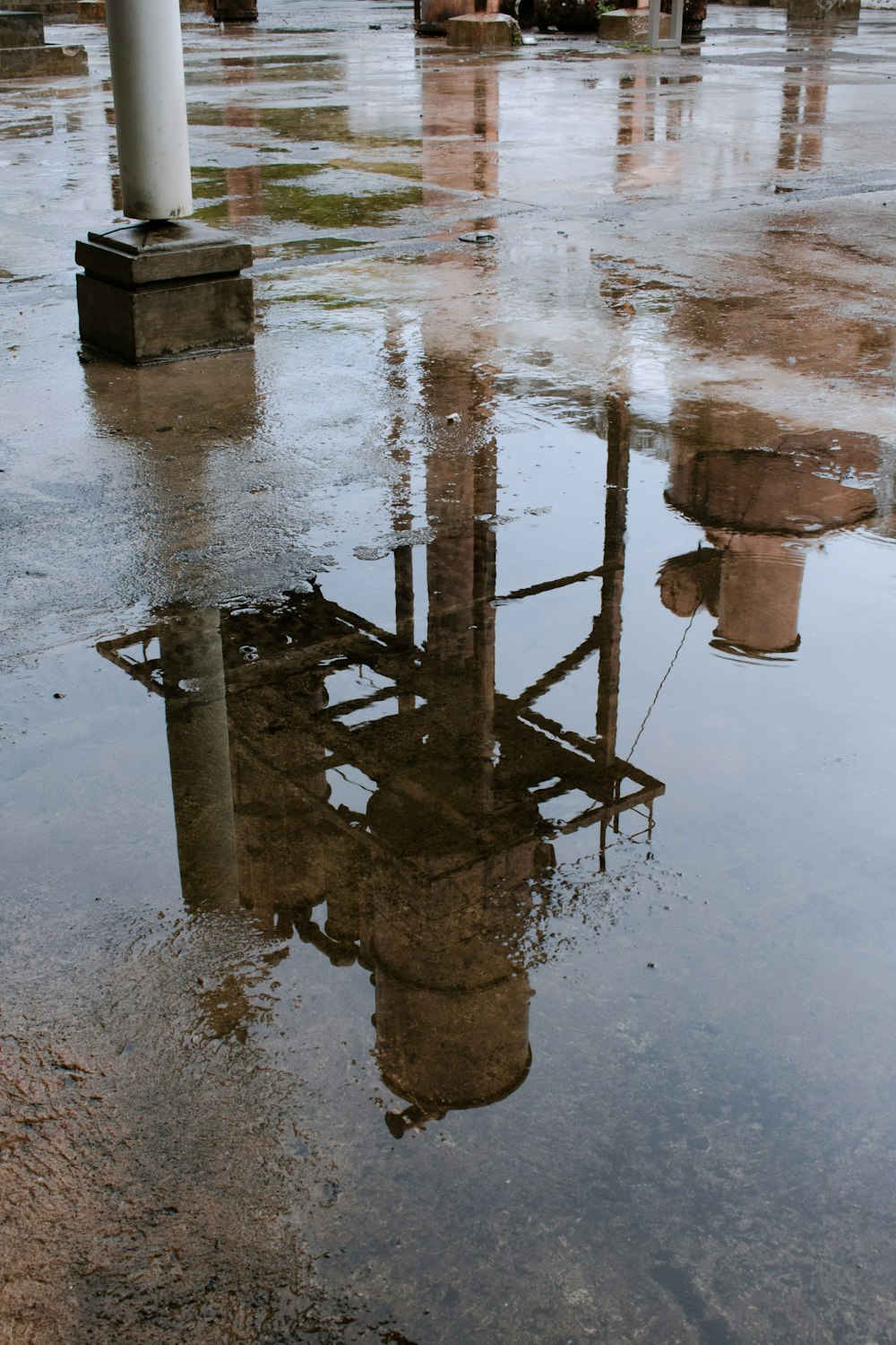 a reflection of a building in a puddle of water