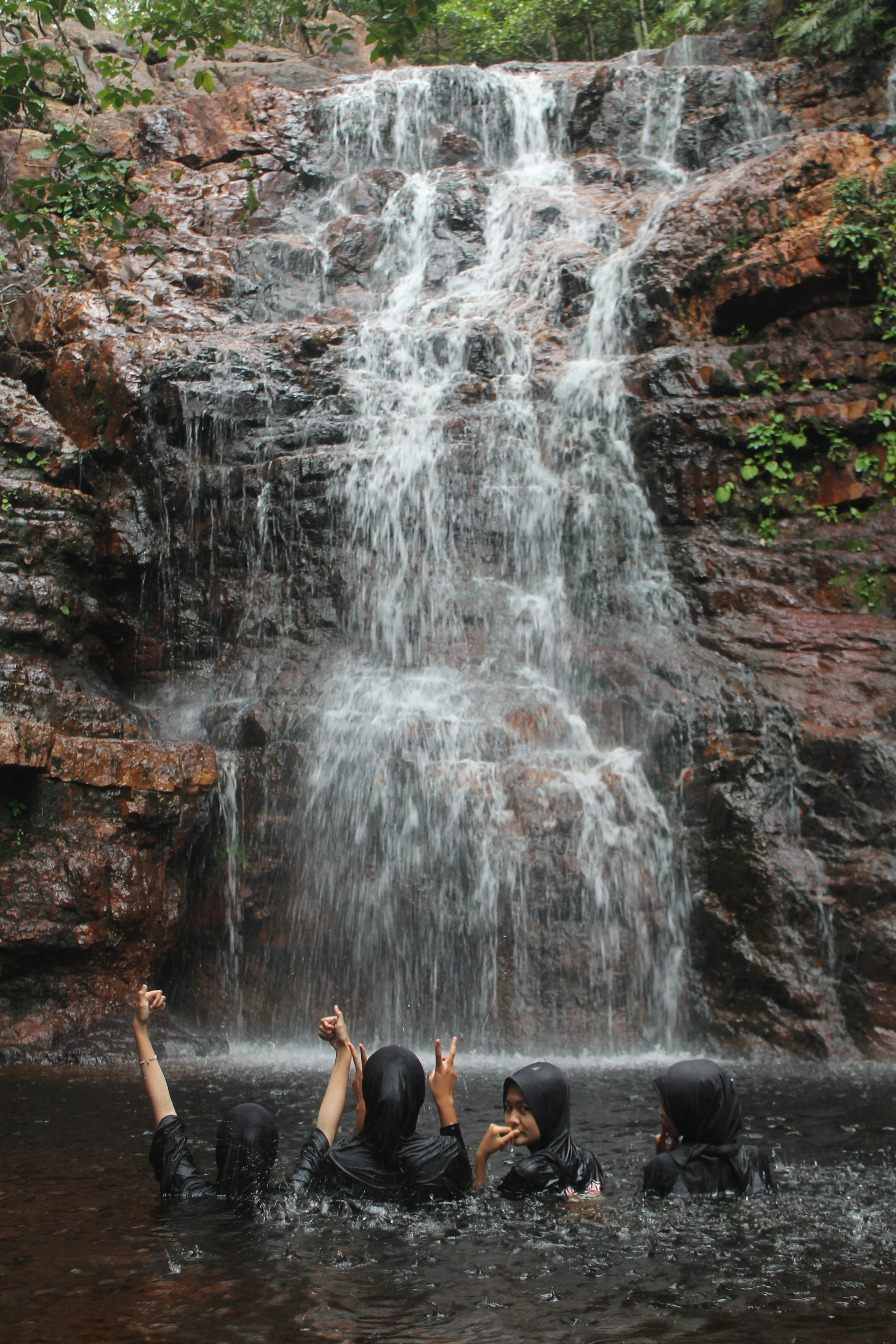Un gruppo di persone in piedi di fronte a una cascata
