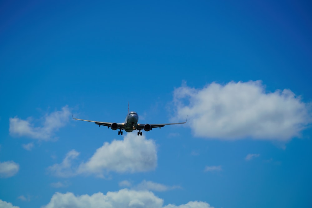 Ein großes Düsenflugzeug fliegt durch einen blauen, wolkenverhangenen Himmel