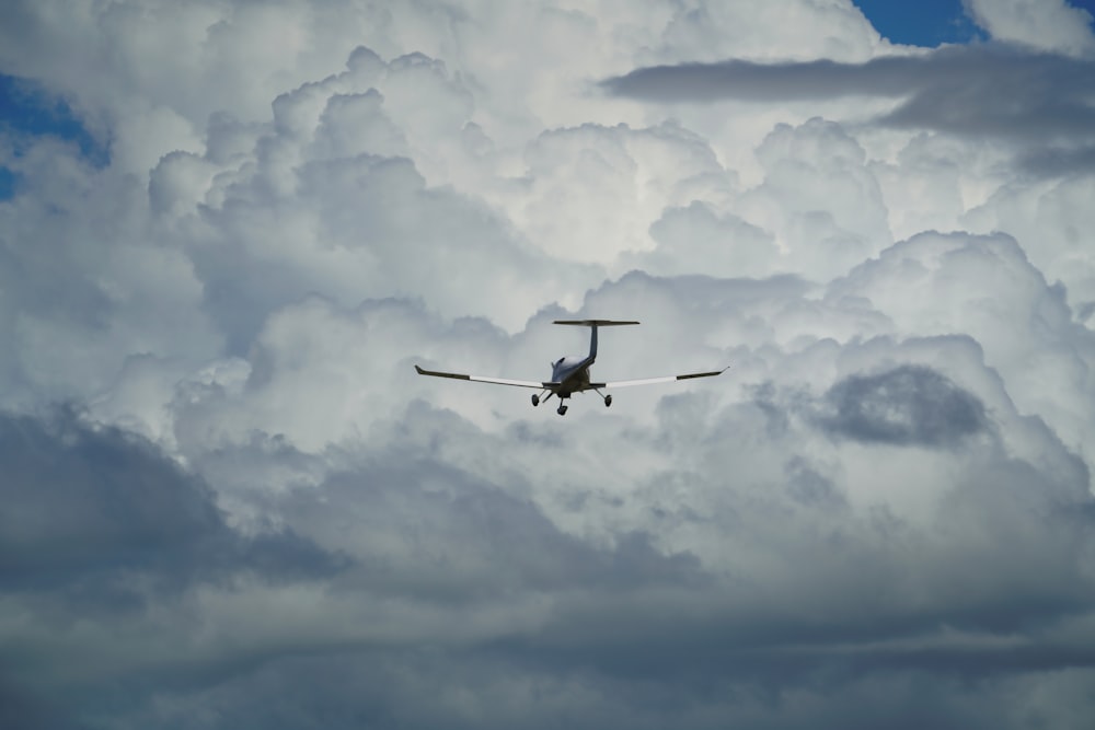 a plane is flying through a cloudy sky